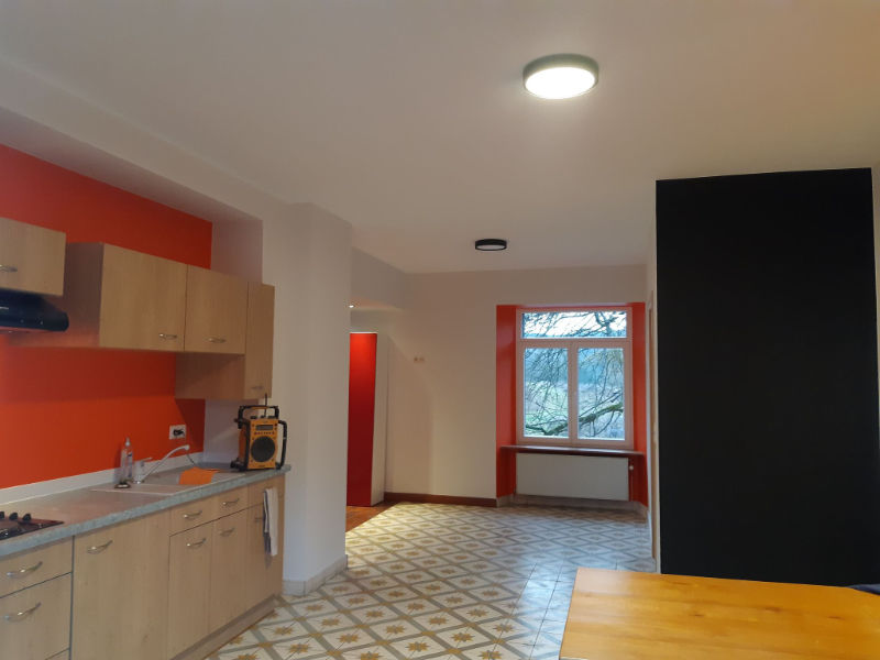 vue globale sur une cuisine peinte en blanc, orange et une touche de noir